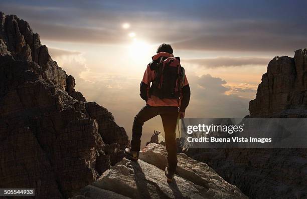 lone climber on a mountain at sunrise - randonnée de haute montagne photos et images de collection