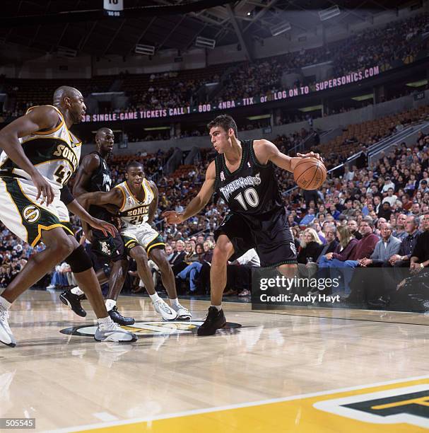 Guard Wally Szczerbiak of the Minnesota Timberwolves dribbles the the ball as forward Vin Baker of the Seattle SuperSonics plays defense during the...