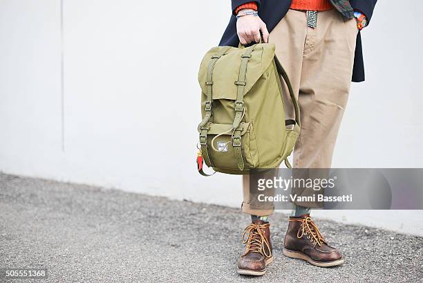 Alessandro Giorgi poses wearing a Fay coat, Redwings shoes and Herschel backpack during the Milan Men's Fashion Week Fall/Winter 2016/17 on January...