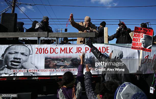 Participants hand out souvenirs to the public during the annual Martin Luther King Holiday Peace Walk and Parade January 18, 2016 in Washington, DC....