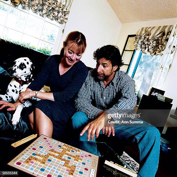 Actress Andrea Evans playing Scrabble at home w. Husband Steve.