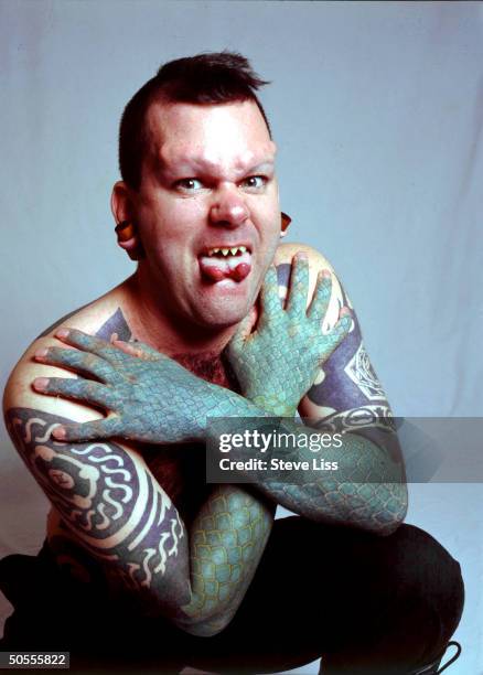 Erik Sprague showing off his reptilian scale tattoos, filed fang teeth, forked tongue & Teflon implants-enlarged forehead, devotee of bod-mod culture...