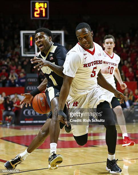 Johnny Hill of the Purdue Boilermakers fights off Mike Williams of the Rutgers Scarlet Knights as he moves the ball up court during the first half of...