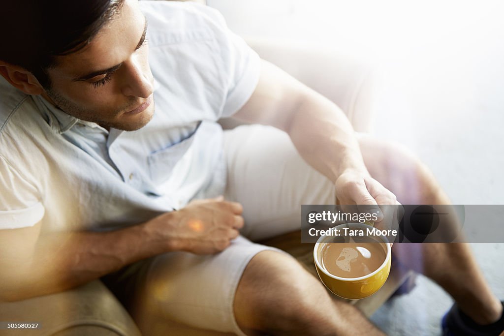 Man drinking coffee in sunlight