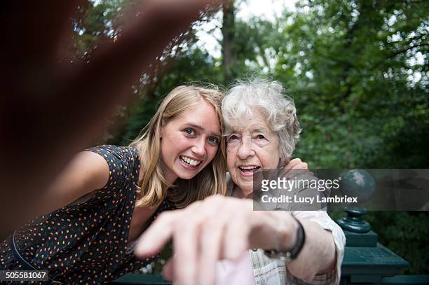 senior (98) lady and young woman making a selfie - old man young woman stock-fotos und bilder
