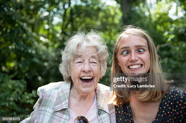 senior (98) lady laughing at young woman squinting - funny face stockfoto's en -beelden