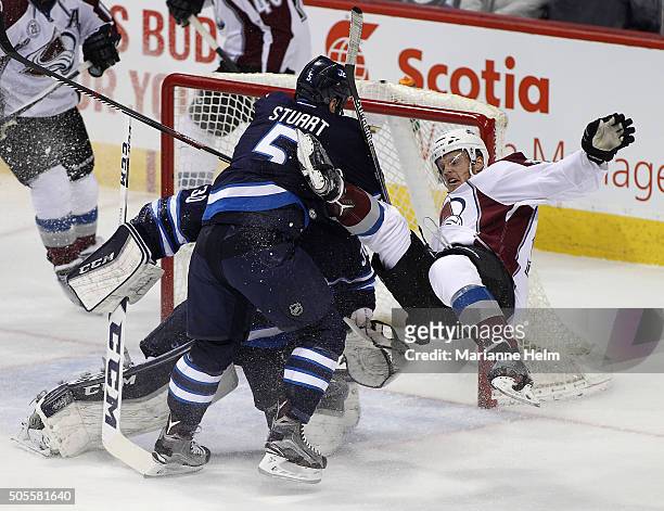 Mark Stuart of the Winnipeg Jets collides with Carl Soderberg of the Colorado Avalanche in first period action in an NHL game at the MTS Centre on...
