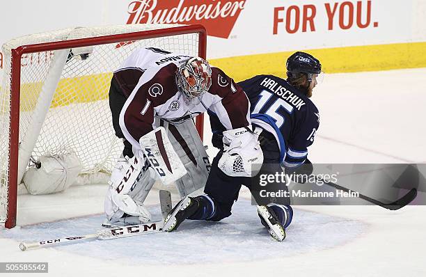 Semyon Varlamov of the Colorado Avalanche moves Matt Halischuk of the Winnipeg Jets as he tries to grab his stick in third period action in an NHL...