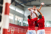 Handball player jumping and shooting at goal.