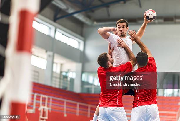 handball player jumping and shooting at goal. - handball stock pictures, royalty-free photos & images