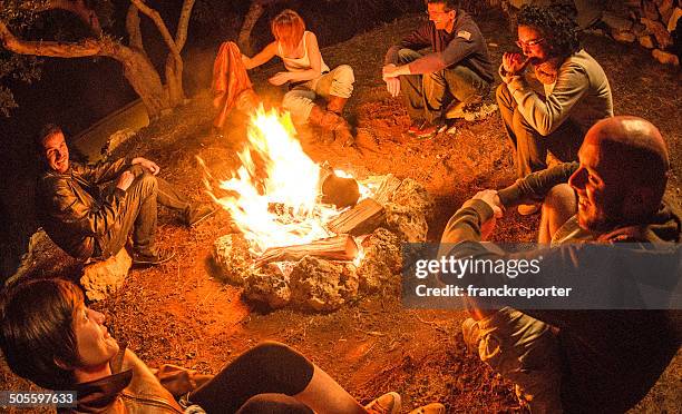 fogueira de acampamento de amigos em círculo no fogo - fogueira de acampamento imagens e fotografias de stock