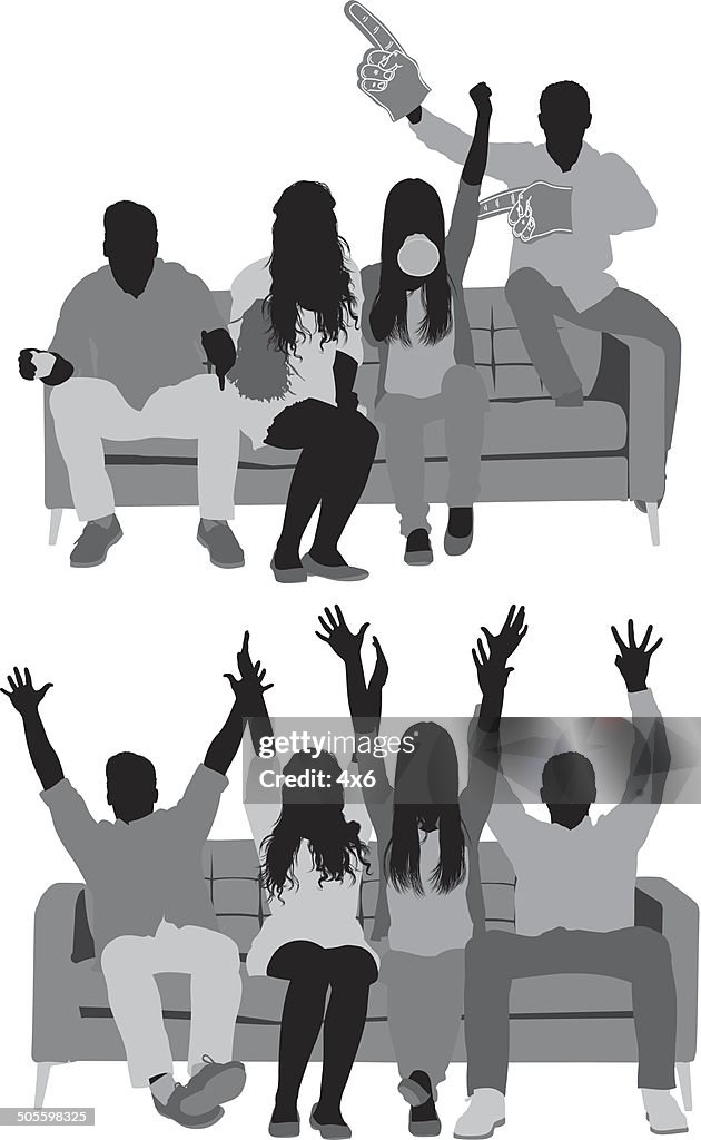 Friends sitting on couch and watching football match