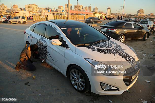 Palestinian artist Belal Khaled intricately paints graffiti on the car.