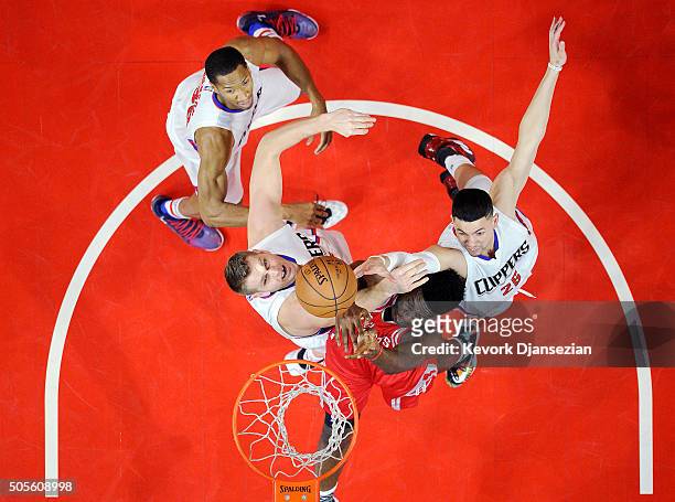 Clint Capela of the Houston Rockets battles for the ball with Cole Aldrich Austin Rivers and Wesley Johnson of the Los Angeles Clippers during the...