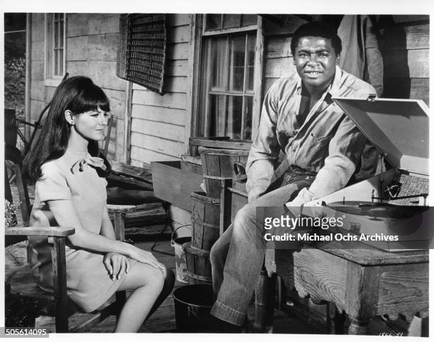 Shelley Fabares and D'Urville Martin listen to the first smash hit record of their friend in a scene from the movie "A Time to Sing", circa 1968.