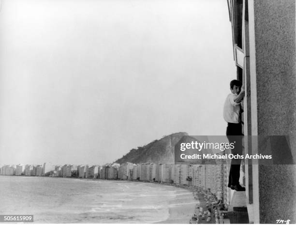 Jean-Paul Belmondo holds onto the side of the building in a scene from the United Artist movie "That Man from Rio", circa 1964.