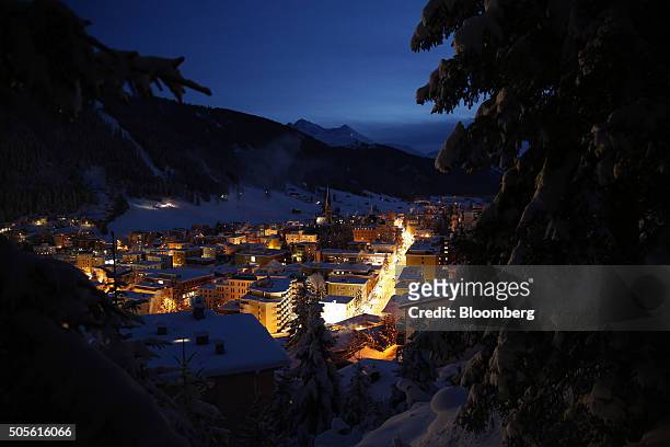 St. John's church, centre, sits surrounded by snow-covered residential buildings illuminated at night in Davos, Switzerland, on Monday, Jan. 18,...