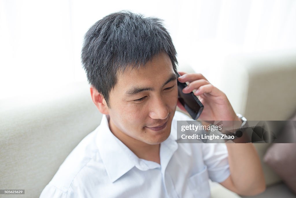 Man with mobile phone on sofa