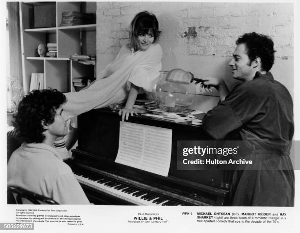 Michael Ontkean, Margot Kidder and Ray Sharkey talk over a piano in a scene from the 20th Century Fox movie "Willie & Phil" circa 1980.