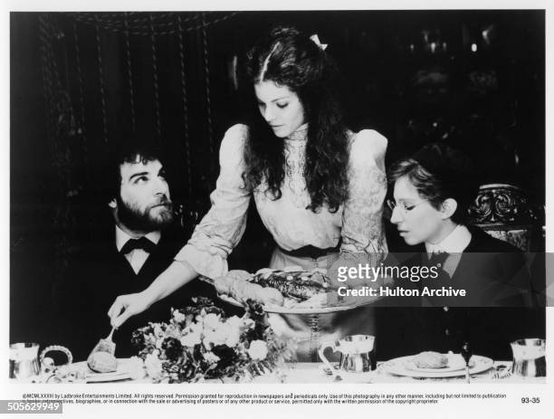 Mandy Patinkin, Amy Irving and Barbra Streisand at a dinner table in a scene in the movie "Yentl" circa 1983.