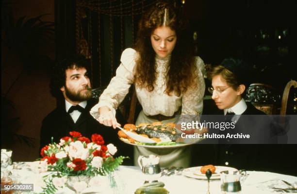 Mandy Patinkin looks lovingly at Amy Irving as she serves Barbra Streisand stands on a ferry boat in a scene in the movie "Yentl" circa 1983.