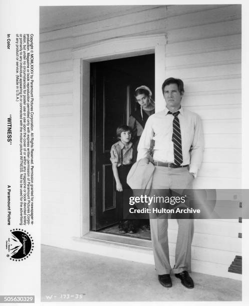 Kelly McGillis and Lukas Haas looks after Harrison Ford in a scene from the Paramount Pictures movie "Witness" circa 1985.