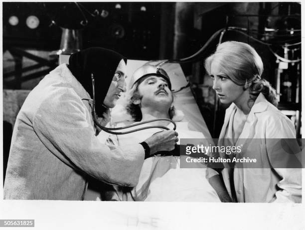 Marty Feldman listens to Gene Wilders' heart as Teri Garr looks on in a scene from the movie "Young Frankenstein" circa 1974.