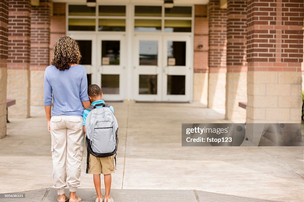 Nervous boy. First day of school.  Holds on to mom.