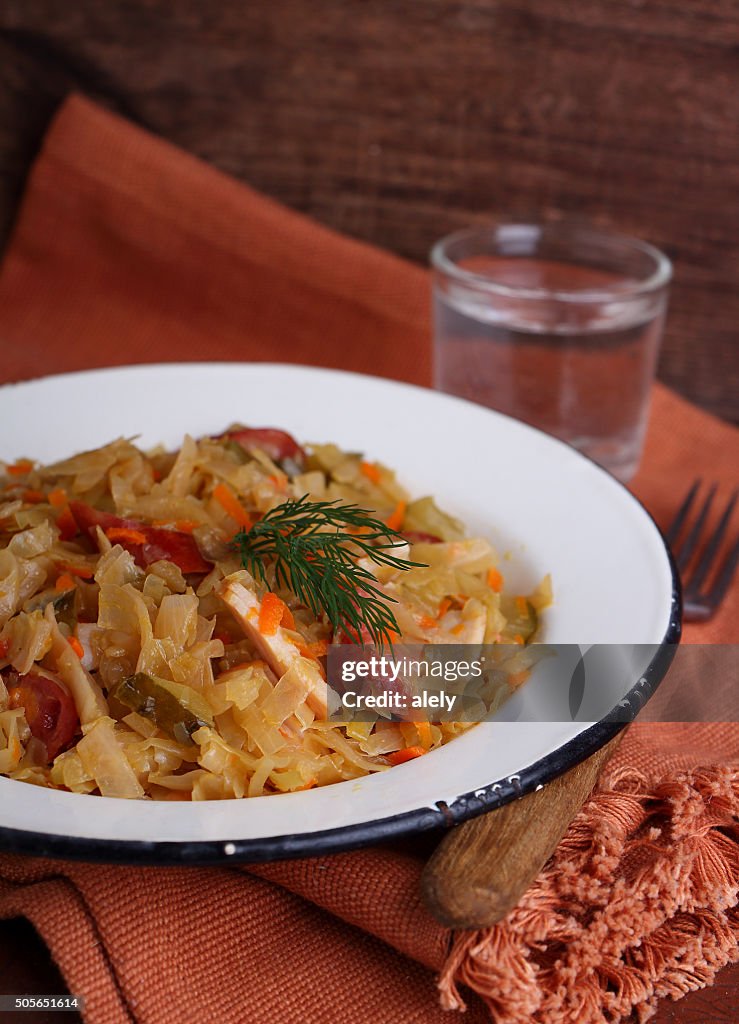 Sauerkraut with sausage onions and carrots in a white plate