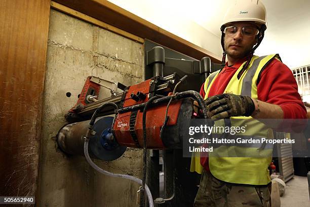 Diamond driller Sunny Kirby drills a hole in the wall used by burglars to access the underground vault of the Hatton Garden Safe Deposit Company...
