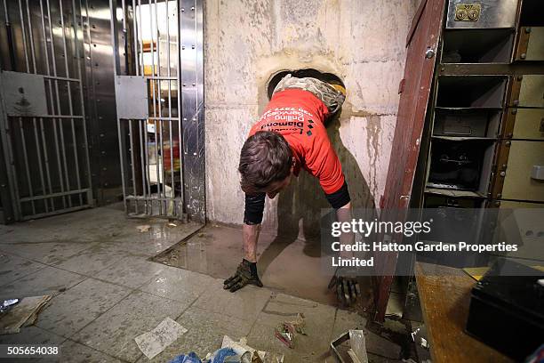 Diamond driller Sunny Kirby climbs through the hole used by burglars to access the underground vault of the Hatton Garden Safe Deposit Company which...