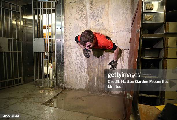 Diamond driller Sunny Kirby climbs through the hole used by burglars to access the underground vault of the Hatton Garden Safe Deposit Company which...