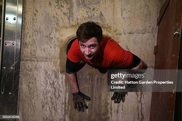 Diamond driller Sunny Kirby climbs through the hole used by burglars to access the underground vault of the Hatton Garden Safe Deposit Company which...