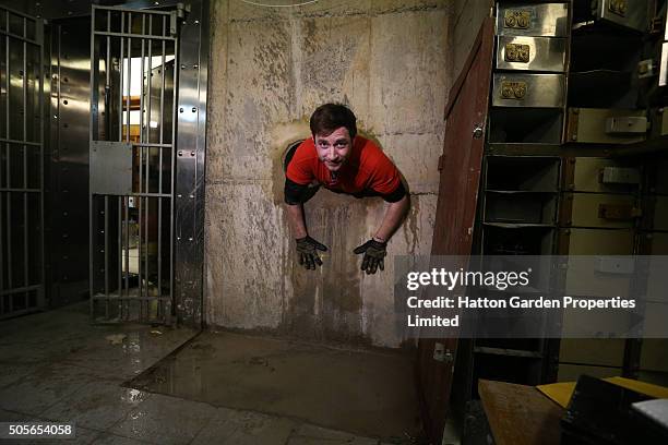 Diamond driller Sunny Kirby climbs through the hole used by burglars to access the underground vault of the Hatton Garden Safe Deposit Company which...