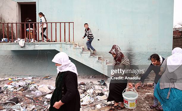 Residents carry plastics buckets filled with water after the curfew ended in the Silopi district of Sirnak, Turkey on January 19, 2016. Some of the...