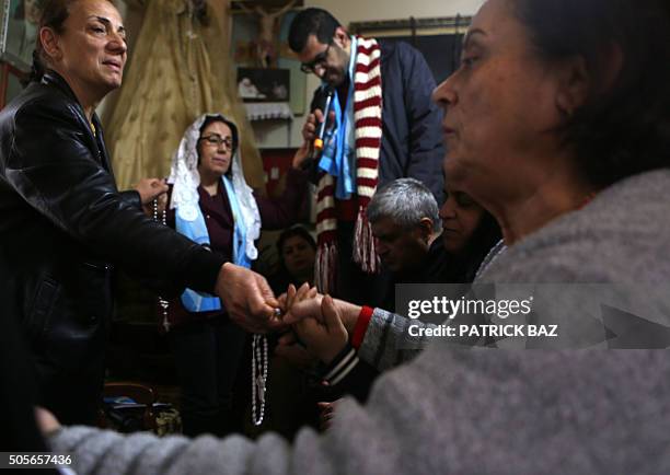 Lebanese Christian women hold hands as a local prayer leader leads a mystical quasi-religious service in an appartment in a popular neighborhood of...