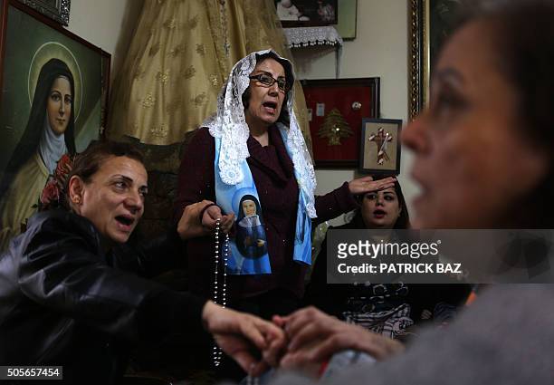 Lebanese Christian women hold hands as a local prayer leader leads a mystical quasi-religious service in an appartment in a popular neighborhood of...