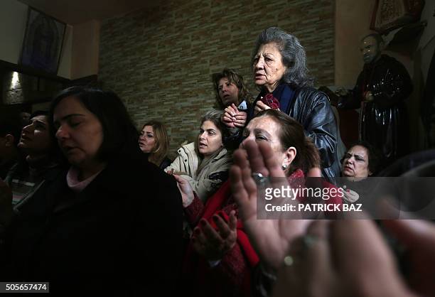 Lebanese Christian women hold hands during a mystical quasi-religious service in an appartment in a popular neighborhood of Beirut on January 19,...