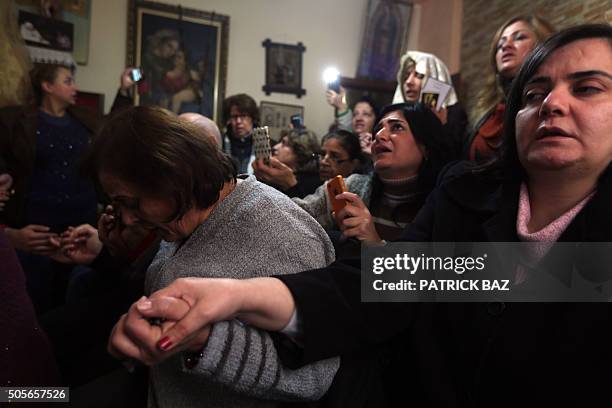 Lebanese Christian women hold hands during a mystical quasi-religious service in an appartment in a popular neighborhood of Beirut on January 19,...