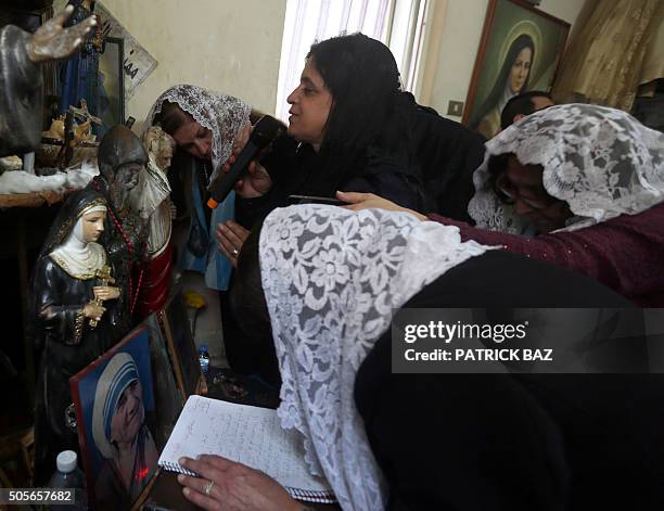 Lebanese Christian women gather around fellow Christian Catherine during a mystical quasi-religious service at her appartment in a popular...