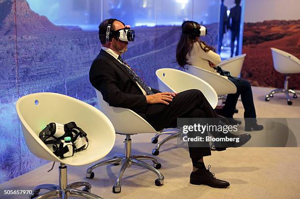 An attendee watches 'Collisions', a 15 minute film by artist Lynette Wallworth, on a Samsung Gear VR virtual reality headset, developed jointly by...