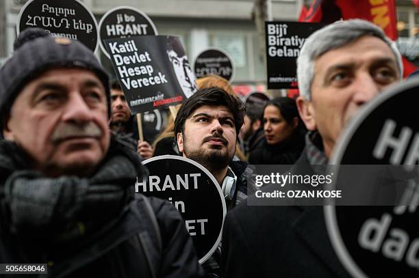 People hold placards reading "We all are Hrant, we all are Armenians" during a commemoration ceremony for slain journalist Hrant Dink, in Istanbul,...