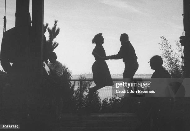 Silhouette of a pair of partygoers engaging in jumping fad.