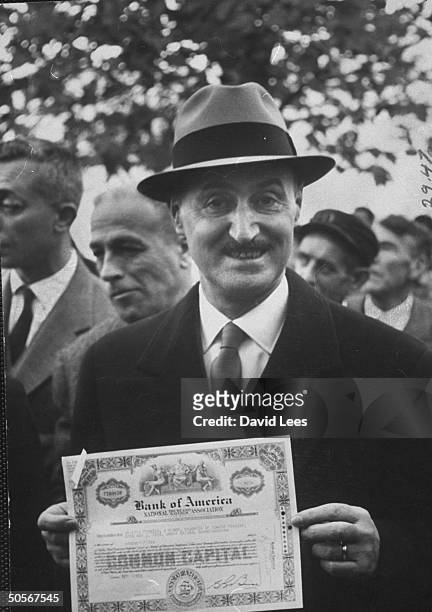 Banker Aurelio Gandini holding stock certificate that will be given to every gualified resident of the village of Sam Marco.