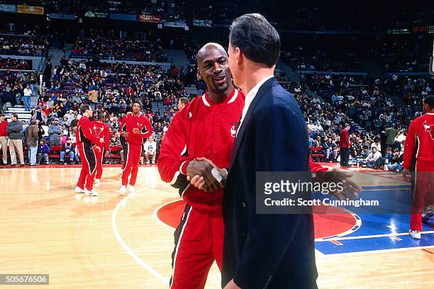 Michael Jordan of the Chicago Bulls shakes hands with Doug Collins of the Detroit Pistons on January 21, 1996 at the Palace of Auburn Hills in Auburn...