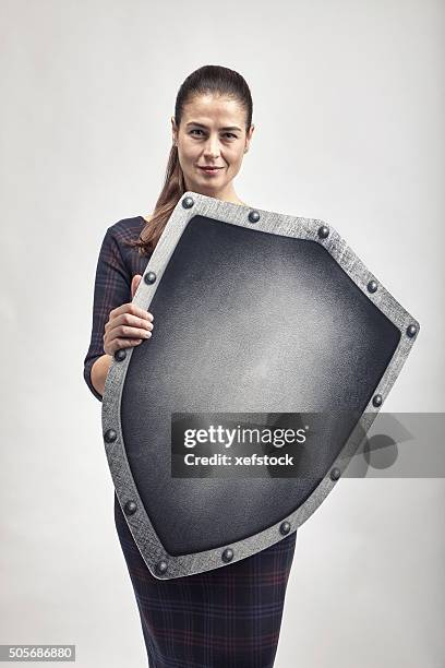 woman protecting herself with a shield - heldin stockfoto's en -beelden