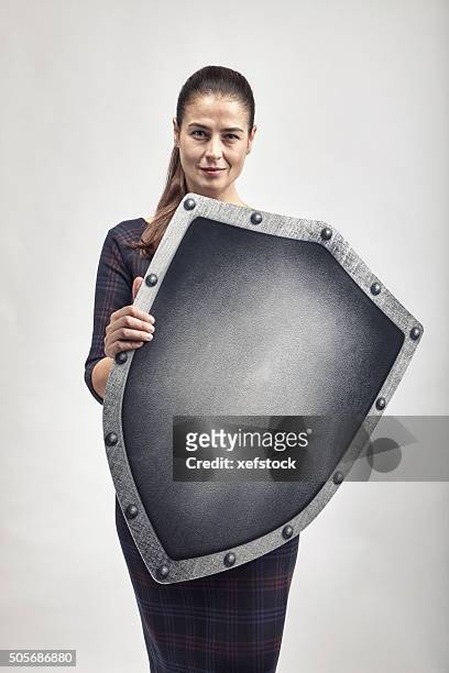 woman protecting herself with a shield - shielding stock pictures, royalty-free photos & images