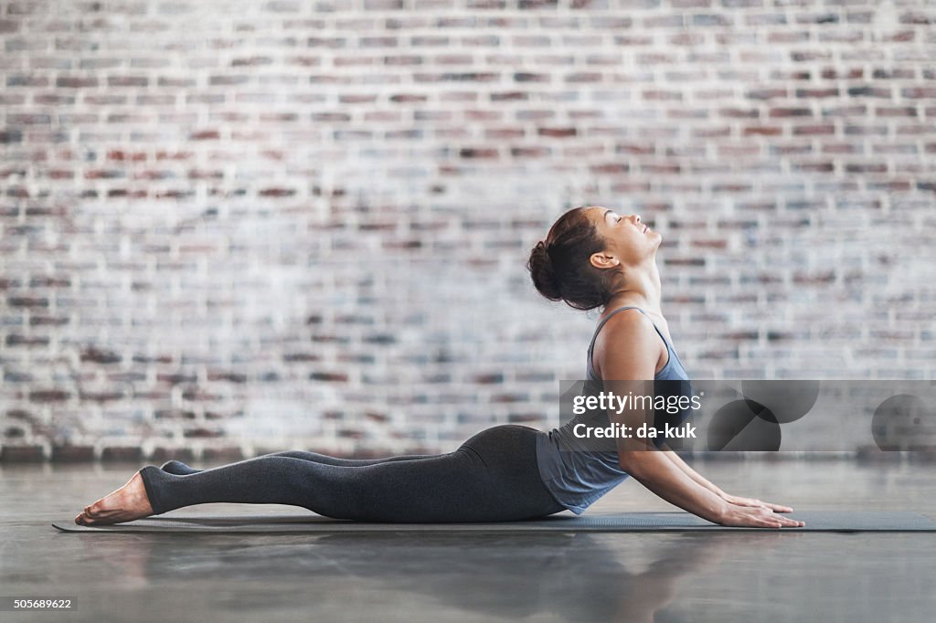 Mujer joven haciendo ejercicios de Yoga meditación y de estiramiento