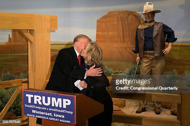 Wax statue of John Wayne watches as Republican presidential candidate Donald Trump kisses John Wayne's daughter, Aissa, during a news conference at...
