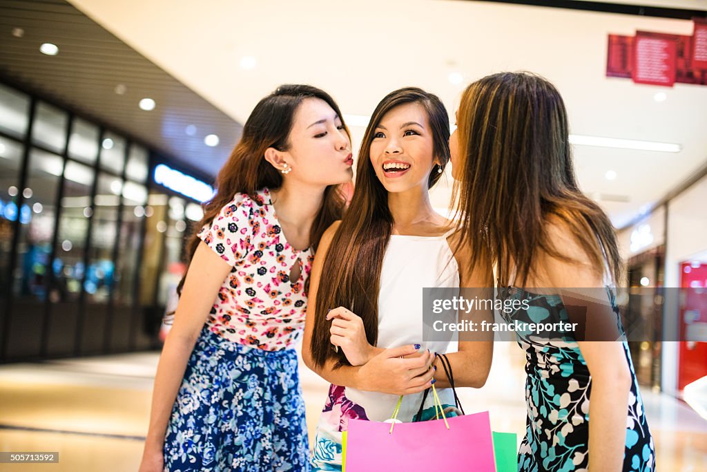 Asiática amigos de compras no centro comercial